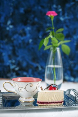 Bir fincan sıcak çay ve kek mavi bir arka plan üzerine. D kavramı