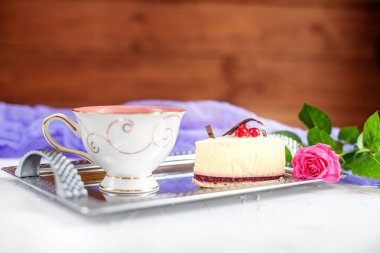 Kek ve bir tepsi ahşap arka plan üzerinde sıcak çay. Kavramı 