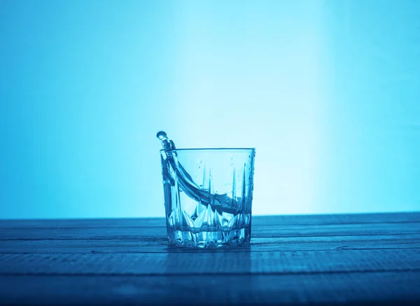 Água pura em vidro sobre um fundo azul. O conceito de beverag — Fotografia de Stock