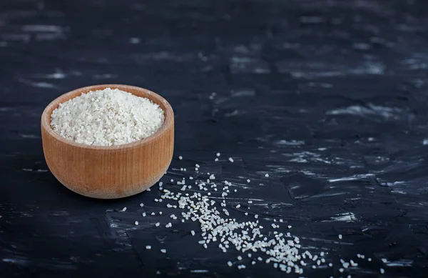 Cuenco de arroz pulido crudo sobre fondo negro. El concepto de — Foto de Stock