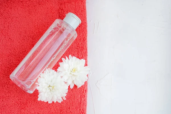 Facial cosmetic and towel on a white background. Top view. The c