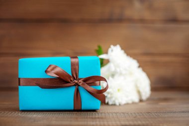 Bir hediye ve çiçek ile ahşap arka plan. Anne kavramı