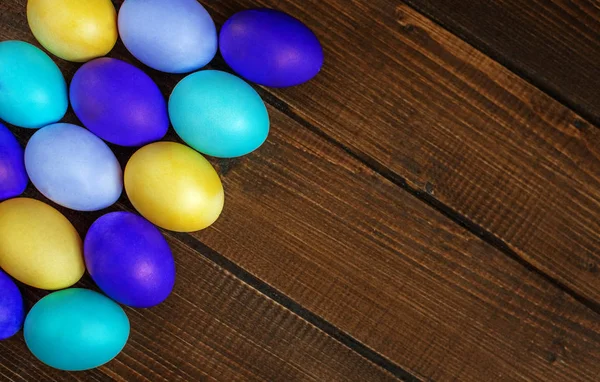 Beaucoup d'œufs de Pâques colorés sont sur un fond en bois. Concept et — Photo