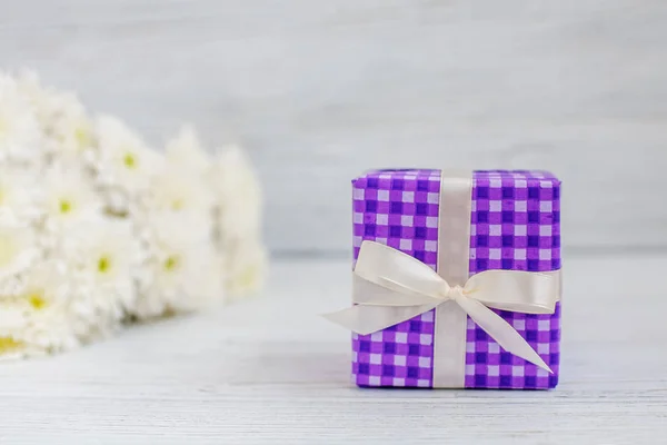 Purple box with a gift and flowers. The concept of Mother's Day, — стокове фото