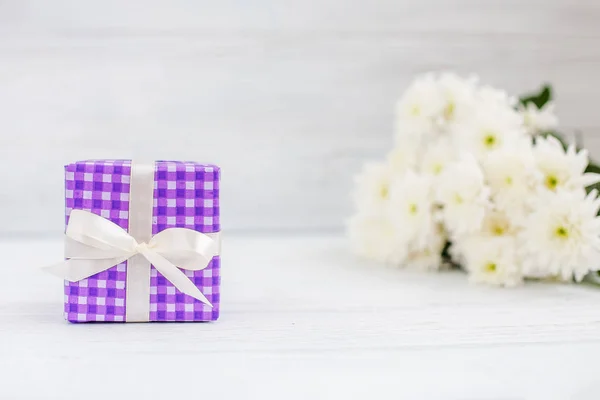 Фіолетовий коробку з подарунок і квіти. Концепція день матері, — стокове фото
