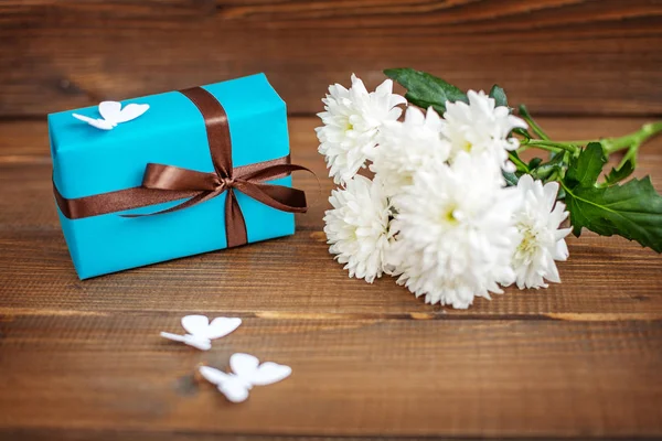 Дерев'яний фон з подарунковою коробкою та квітами для привітання . — стокове фото