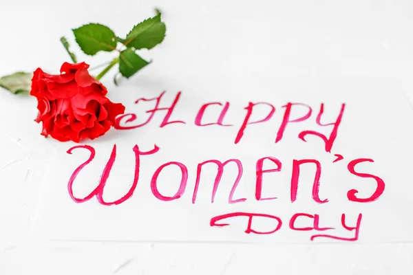 White background with greetings and rose. Concept of Happy Women