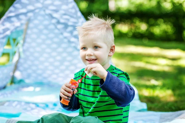 A kisfiú fúj buborékok a parkban. Életmód fogalma — Stock Fotó