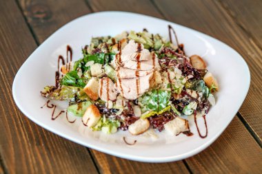 Salatalık ve tavuk ve beyaz tabakta marul salatası. 