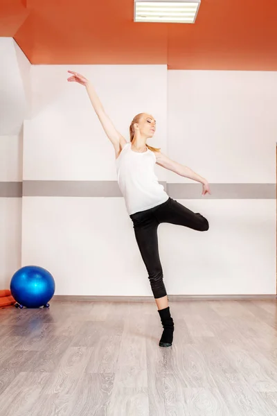 Joven chica delgada bailando en el gimnasio. El concepto de deporte, danza —  Fotos de Stock