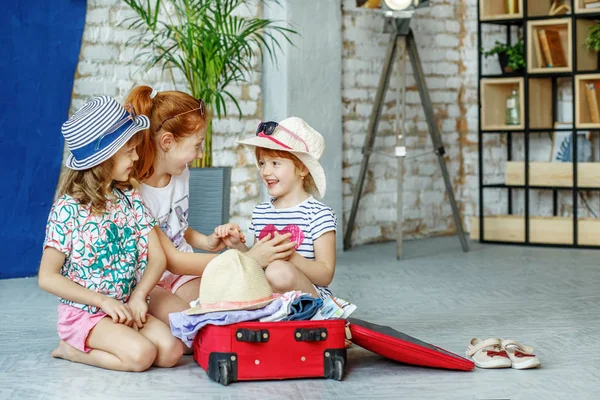 Drie kinderen pak hun bezittingen in een koffer. Concept, lif — Stockfoto