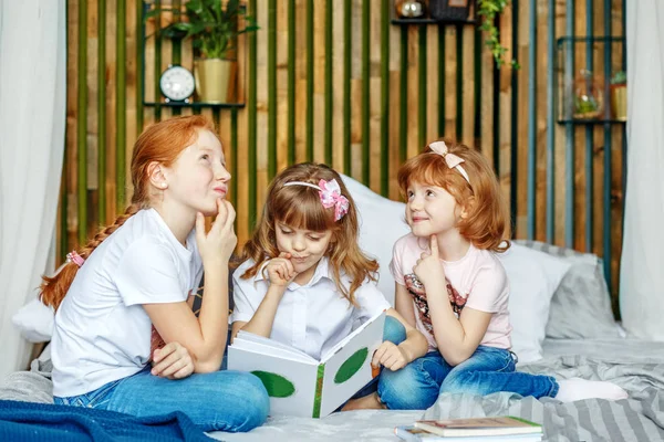 Three children think about what is written in the book. The conc — Stock Photo, Image