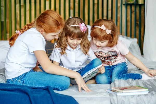 Little girls are considering a book. The concept of lifestyle, c — Stock Photo, Image