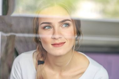 Genç bir kadın pencereden görünüyor. Yaşam tarzı kavramı