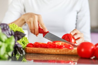 Keskin bir bıçakla domates Dilimleme bir genç adam. Bir kavramdır 