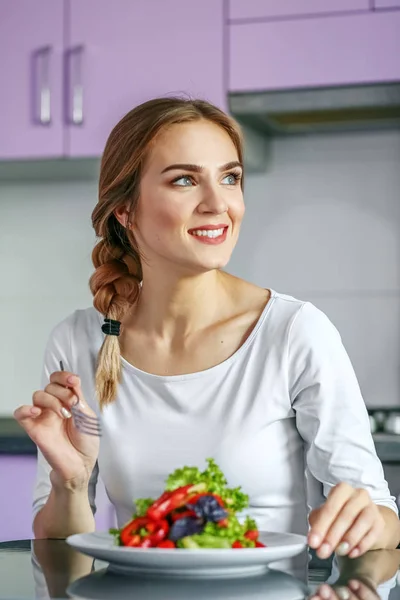 Une femme souriante et heureuse mange une salade de légumes saine. La concession — Photo