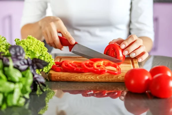 L'hôtesse tranche les légumes dans la cuisine. Faire végétarien — Photo