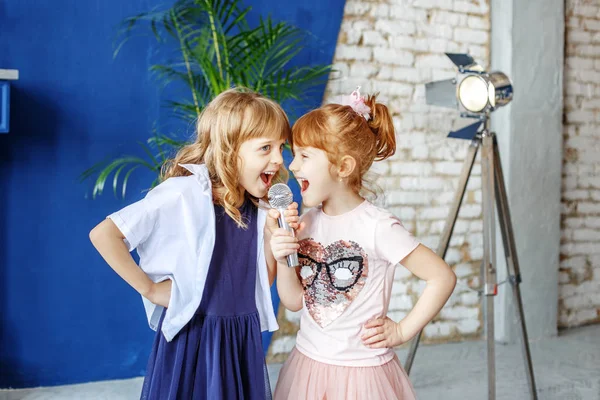 Dos niños graciosos cantan una canción en un micrófono. Grupo. Th — Foto de Stock