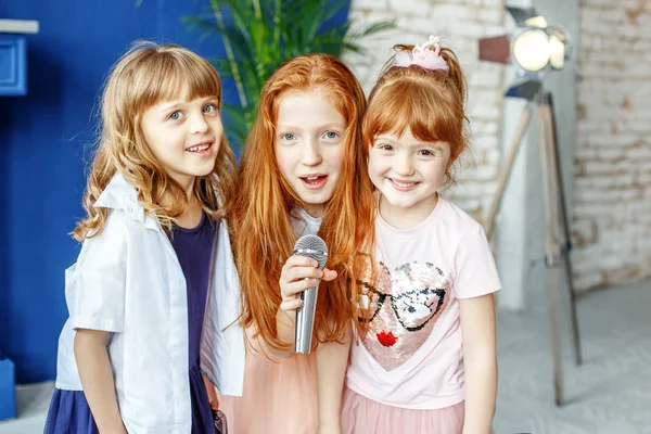 Three kids sing a song in a microphone. Group. The concept is ch — Stock Photo, Image