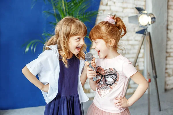 Two happy little children sing a song in karaoke. The concept is — Stock Photo, Image
