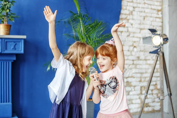 Dos niños divertidos bailan y cantan una canción en el karaoke. El — Foto de Stock