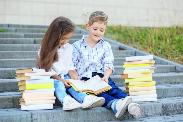 Broder och syster läser en bok. Konceptet är tillbaka till skolan, utbildning, läsning, vänskap — Stockfoto