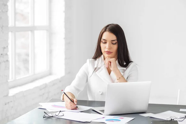 Una giovane donna adulta lavora e pensa. Concetto per il business, brainstorming e fare grandi soldi . — Foto Stock