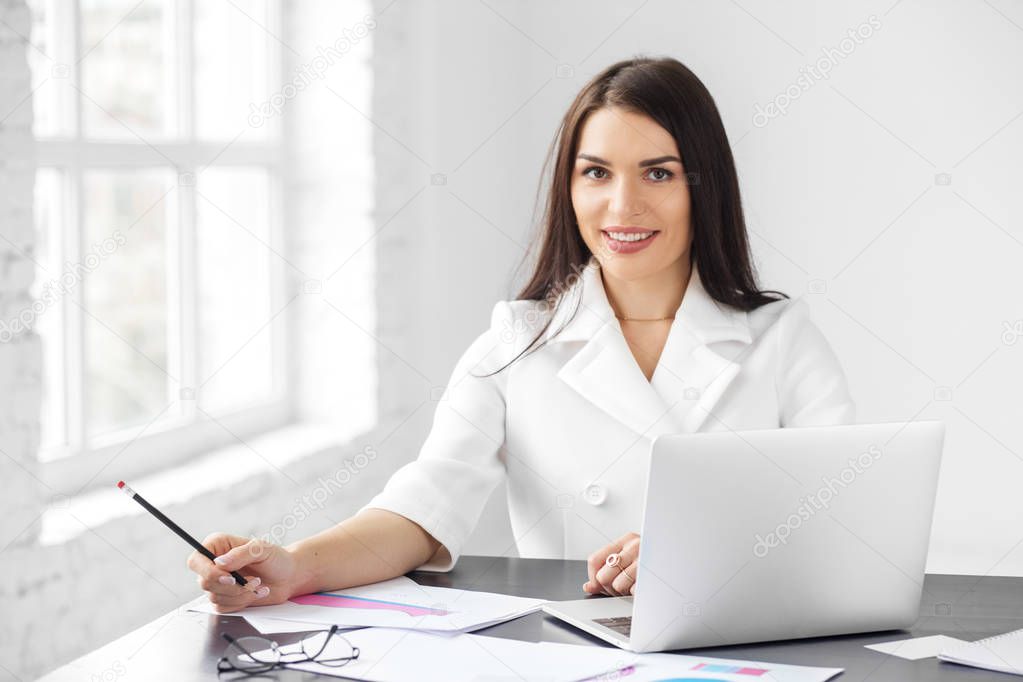 A young adult woman is working and smiling. Concept for business, work and making big money.