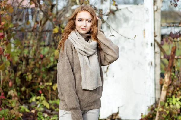 Молодая взрослая девушка в вязаном свитере и шарфе. Концепция образа жизни, осень, косметика и уход . — стоковое фото