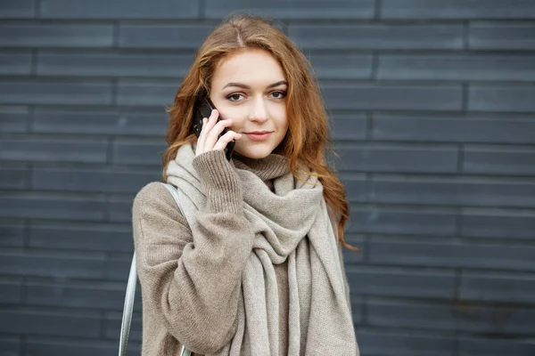 Uma jovem está a falar ao telefone na rua. O conceito de comunicação, trabalho, estilo de vida e juventude — Fotografia de Stock