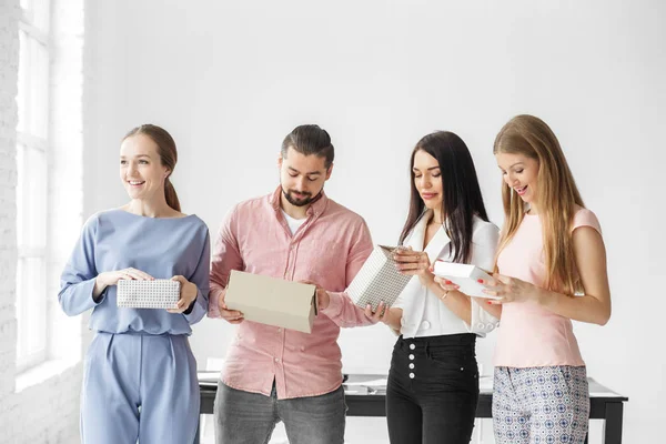 Colegas de la oficina intercambiaron regalos por el Año Nuevo. Un grupo de empleados. El concepto de saludos y regalos para la Navidad . —  Fotos de Stock