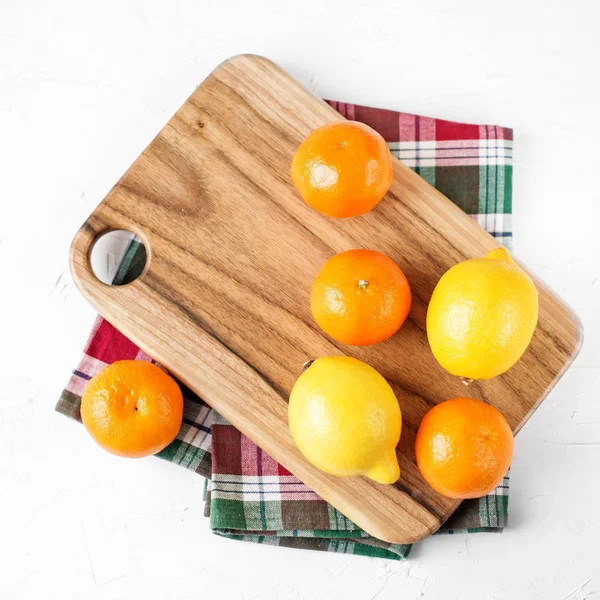 Lemons and tangerines on the kitchen board. Food concept. Square. — Stock Photo, Image