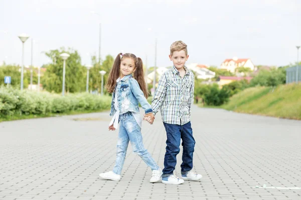 Children walk holding hands. The concept of childhood, back to s — 스톡 사진