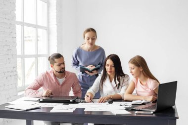 Ofiste bir grup genç girişimci analitikle meşgul. Girişimci konsepti, başarı ve çalışma.