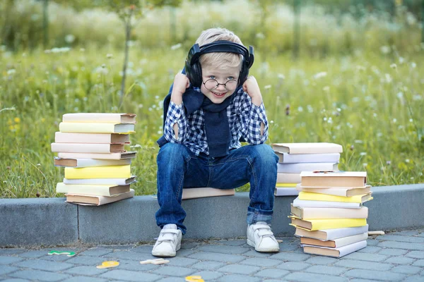 En liten pojke i hörlurar. Tillbaka till skolan. Begreppet lärande, skola, sinne, livsstil och framgång. — Stockfoto