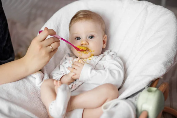 お母さんは幼い野菜のピューレを食べます 子供時代 最初のルアーと赤ちゃんの食べ物の概念 — ストック写真