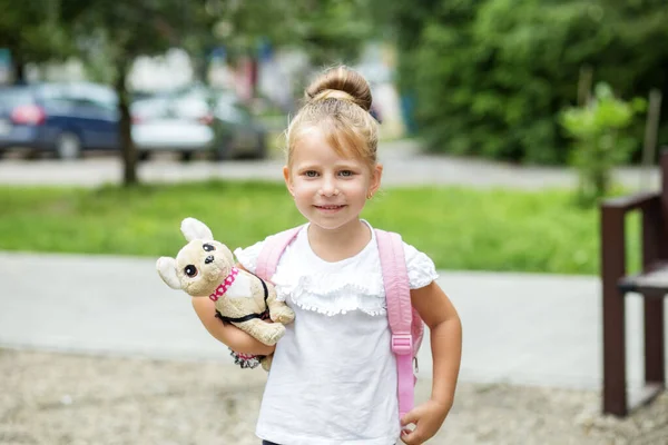 女の子はおもちゃと笑顔を保持しています 学校に戻る 子供時代の概念 — ストック写真