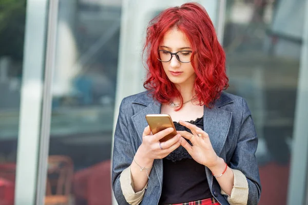 Teen girl with red hair. Correspondence on the Internet. The concept of gen z, chatting, social networks and the Internet.