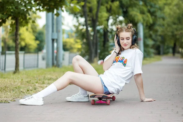 Chica Adolescente Con Monopatín Escucha Música Los Auriculares Gen Concepto — Foto de Stock