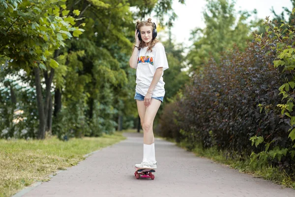 Menina Adolescente Monta Skate Ouve Música Nos Auscultadores General Conceito — Fotografia de Stock