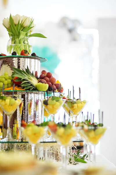 Mix of fruits on the festive table. Pyramid from the glass. The concept of food, catering, restaurant and party celebration.