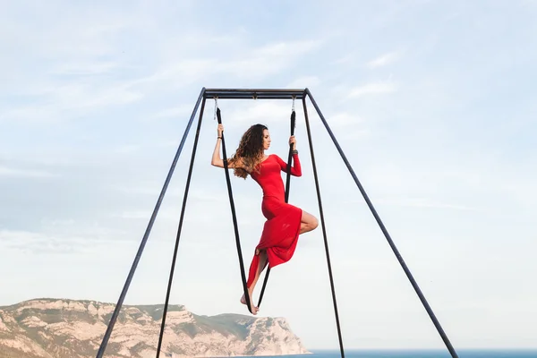 Wanita bergaun merah berlatih yoga fly-dance — Stok Foto