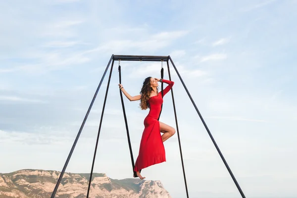 Woman in red dress practicing fly-dance yoga — Stock Photo, Image