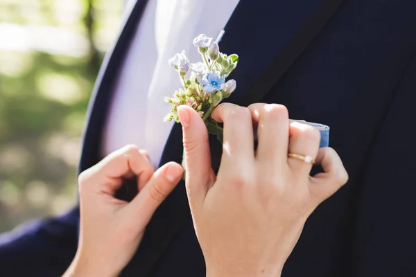 Noiva ajuda o noivo a usar boutonniere — Fotografia de Stock