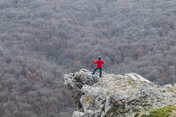 Homem subindo até a borda da rocha — Fotografia de Stock