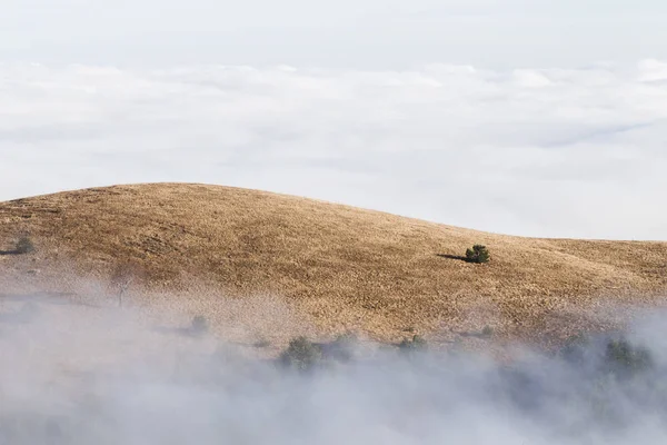 Kefen içinde alçak bulutlar dağ tepeleri — Stok fotoğraf
