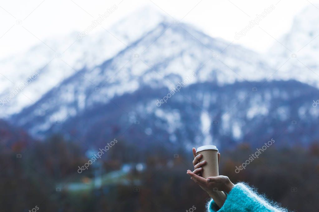 hand holding a cup of warming beverage 