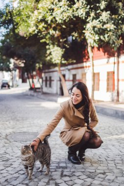 sevimli kız bir kedi okşayarak 