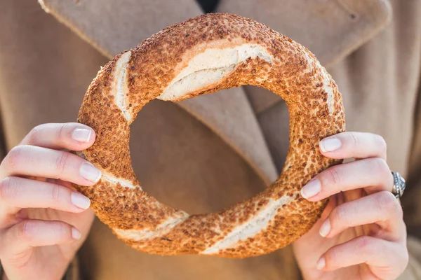 Vrouw houdt een traditionele Turkse simit — Stockfoto