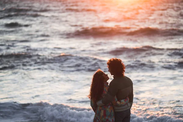 Casal apaixonado na praia ao pôr do sol. — Fotografia de Stock